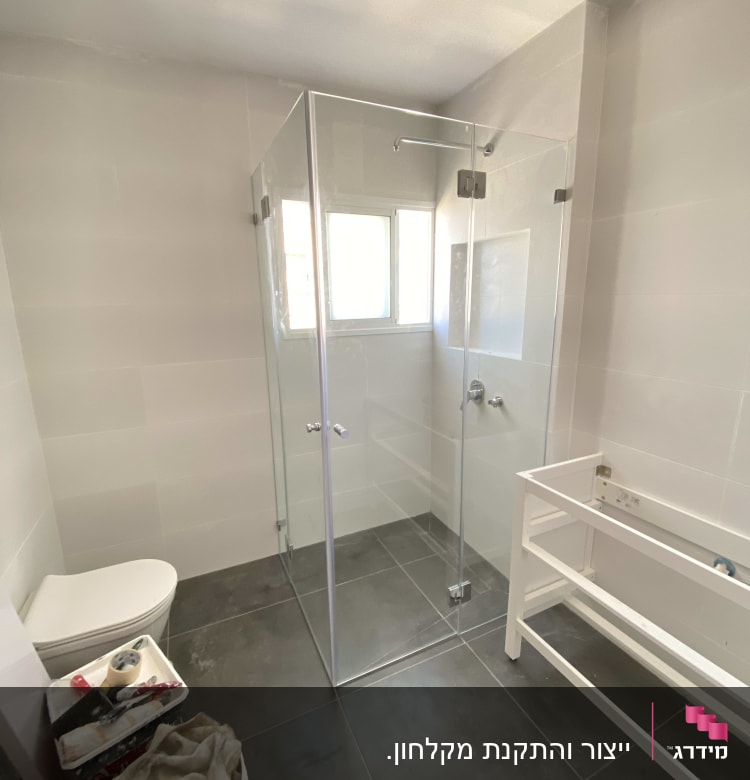 מקלחון זכוכית עם דלתות שקופות בחדר אמבטיה